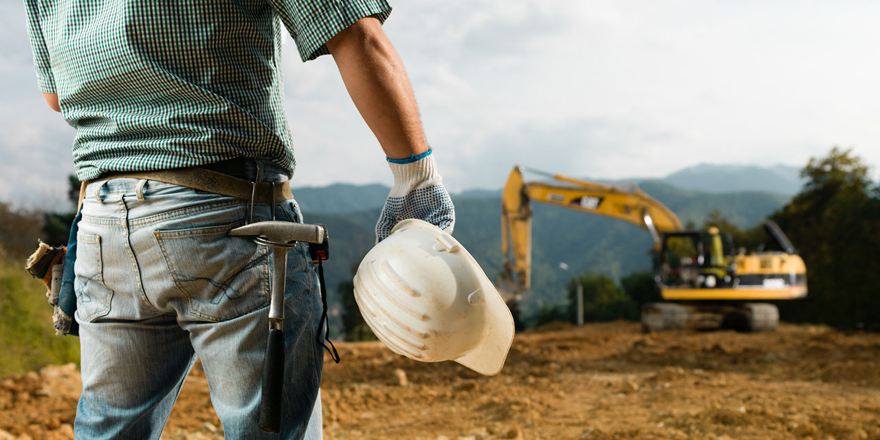 Baustelle mit Baumaschine und Baupersonal